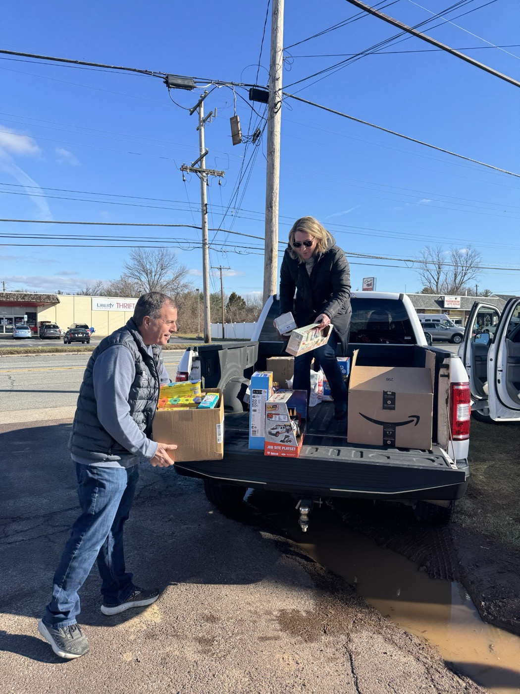 Blue Tree owners loading donated toys into a pickup truck for a community drive