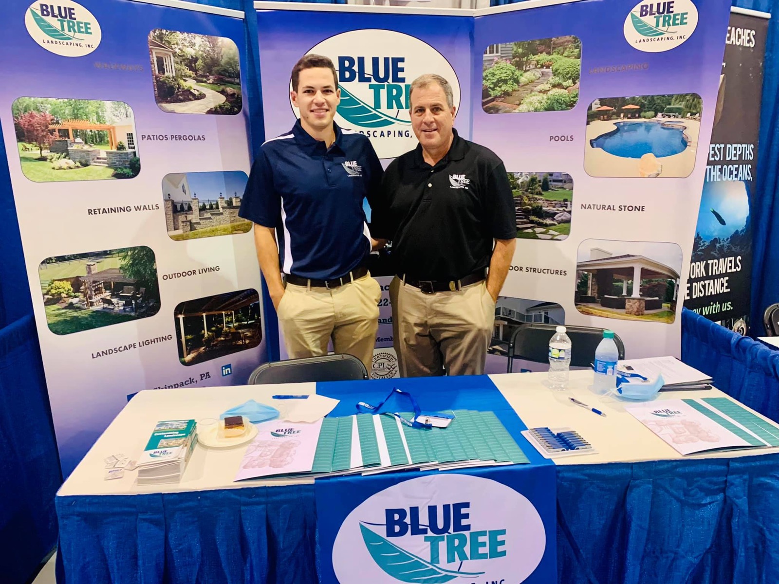 The Blue Tree team at a Southeastern Pennsylvania home and garden show with a branded display of pools, patios, and landscapes